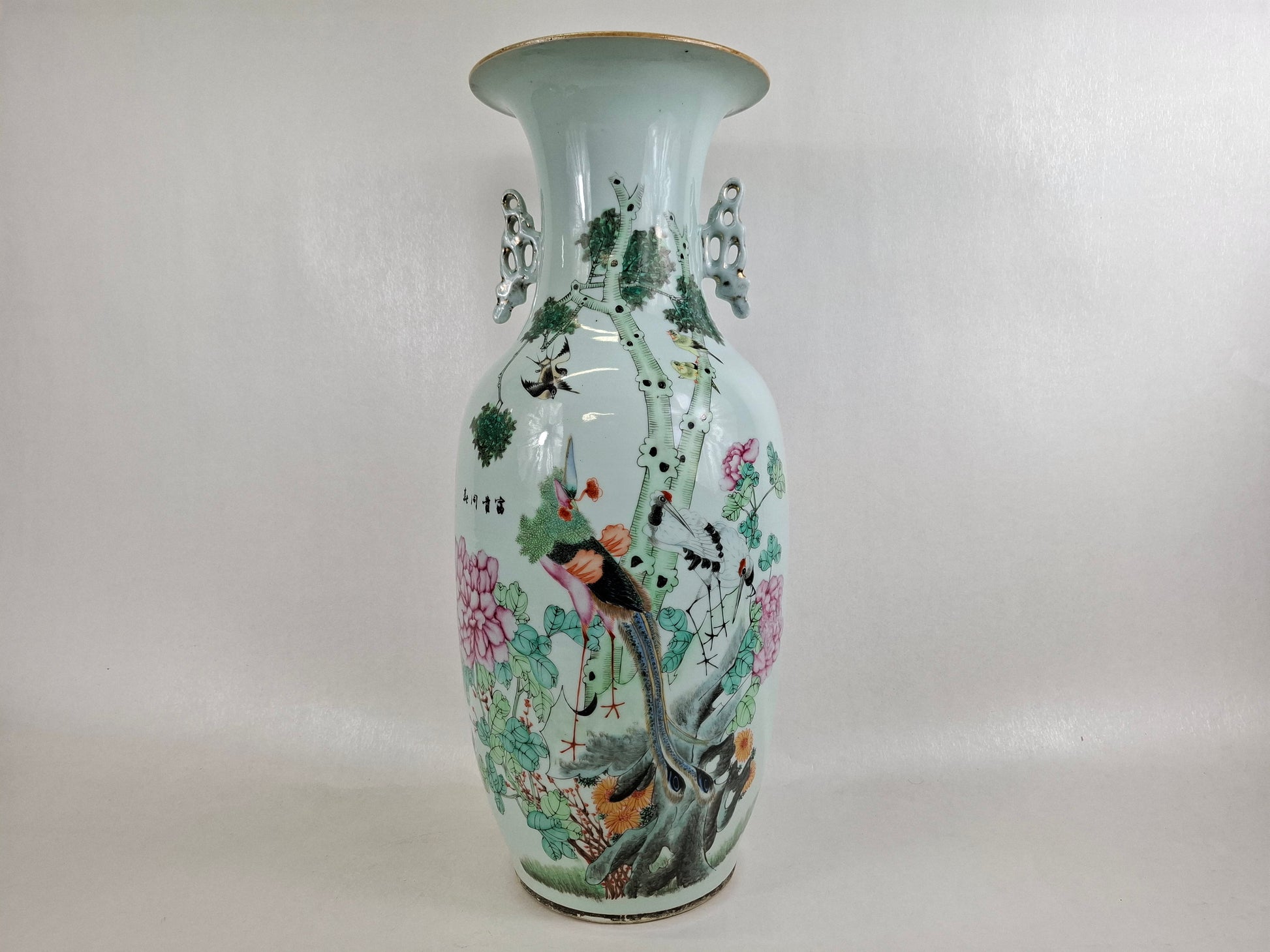 Antique Chinese qianiang polycrhome vase with colorful floral and bird design on a plain background