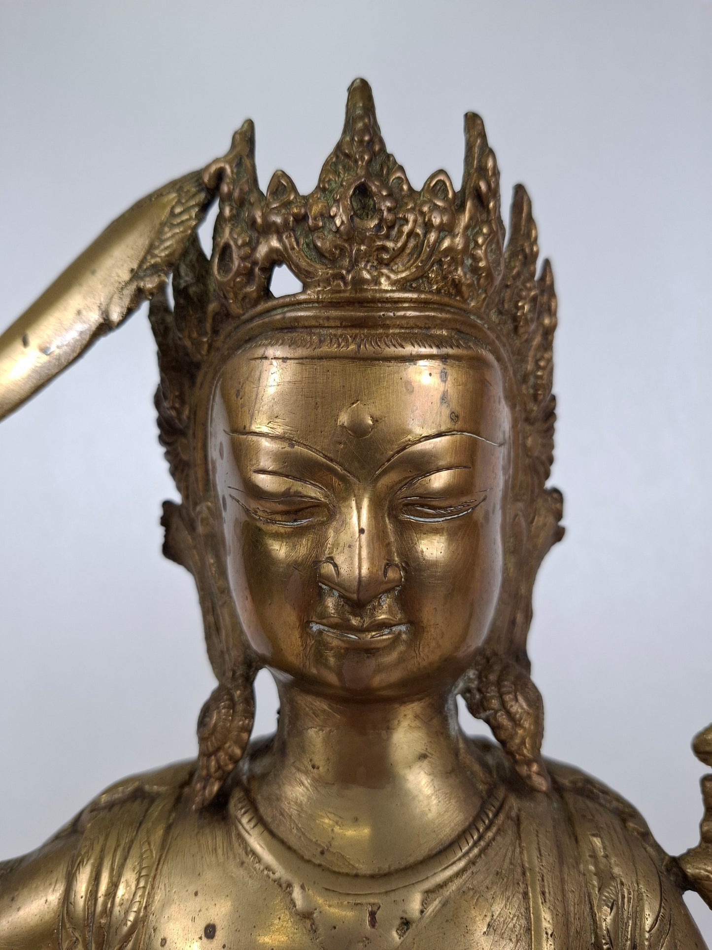 Detail of the face of a  mid-century brass Manjushri bodhisattva statue 