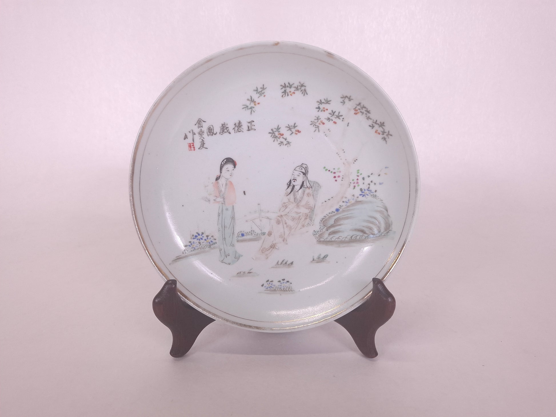 Antique Chinese handpainted qianjiang plate decorated with a garden scene including a Chinese lady and a sage