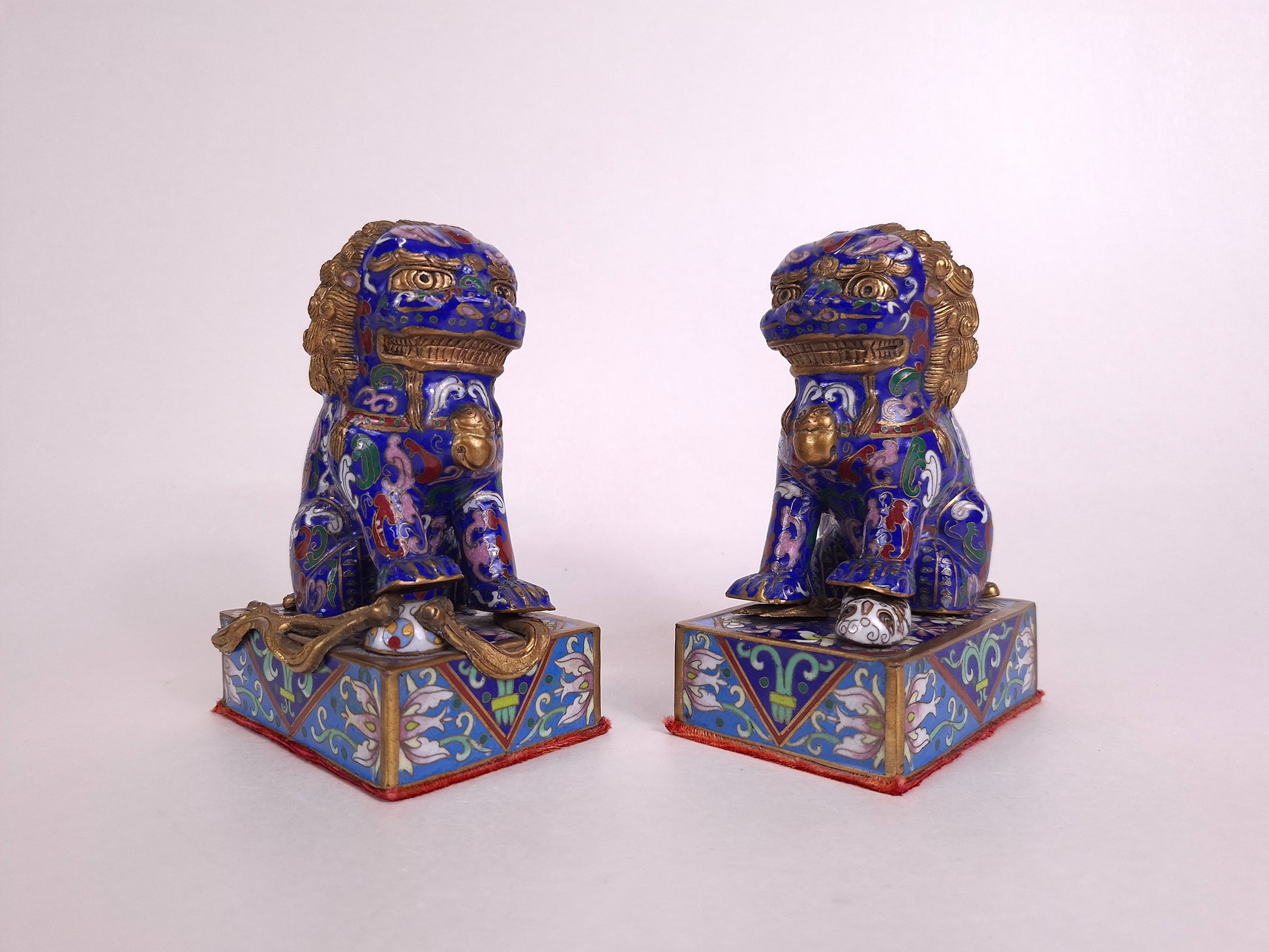 Pair of Chinese cloisonne foo dog guardian lions with flower patterns
