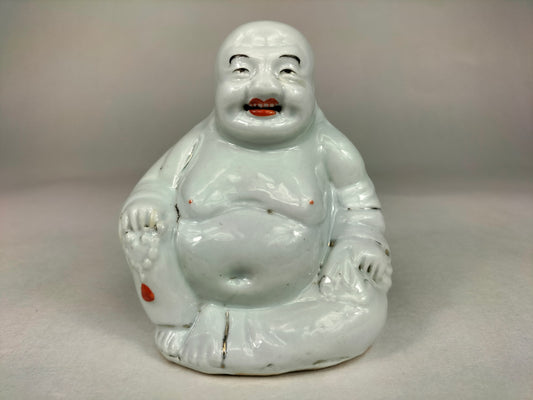 Antique porcelain sitting budda statue laugning. The buddha is dated to be Republic
